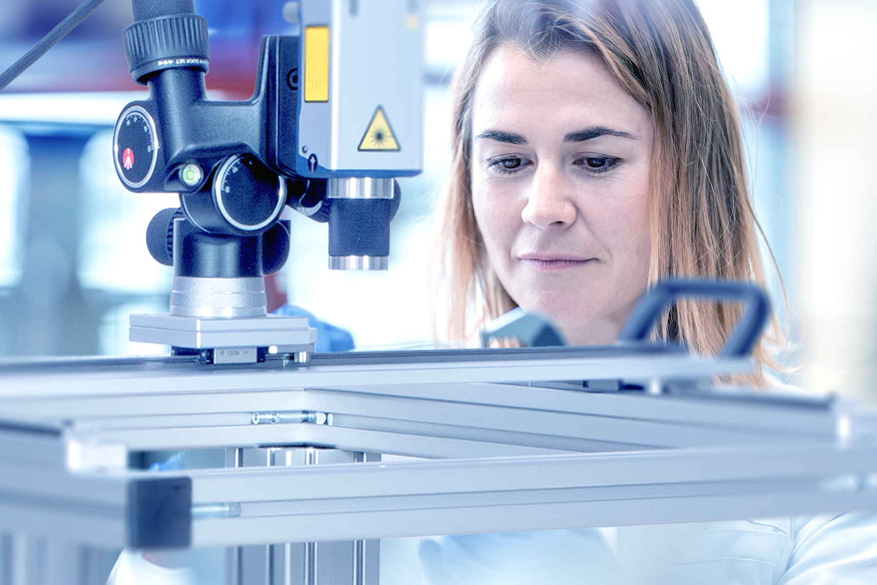 Laboratory employee in front of a laser vibrometer for primary calibration of vibration sensors