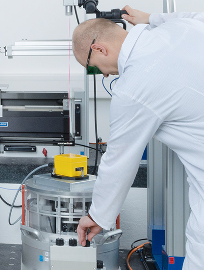 Messtechniker an einem Tieffrequenz-Schwingungserregers mit einem montierten Geophone